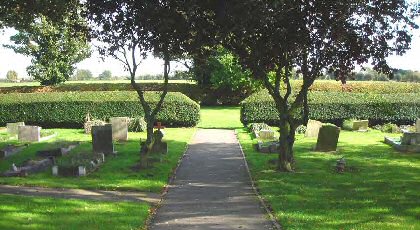 Fig. 10 View east from the churchyard looking over neat hedges that separate the churchyard from the parish burial ground, with a further hedge boundary at the eastern edge bordering agricultural land.