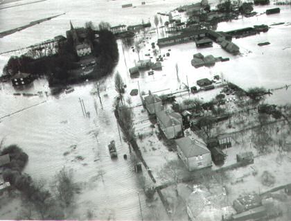 Fig. 7 Churchend after the 1953 flood looking north. The church and rectory are marooned in the top left, with Old Hall Farm opposite, its haystacks swept aside by the flood waters. Nos 15-18 Churchend are to the south.